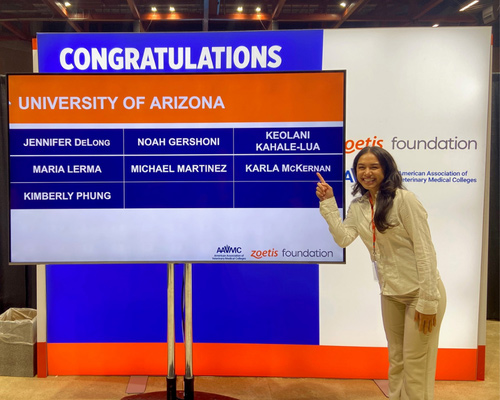 Zoetis Foundation/AAVMC scholarship recipient pointing to her name on congratulations board - Zoetis
