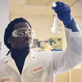 Zoetis scientist examining beaker - Zoetis