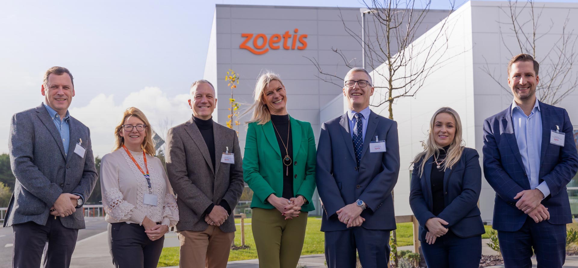 Seven executives and government officials stand outside manufacturing facility for animal health company Zoetis in Ireland